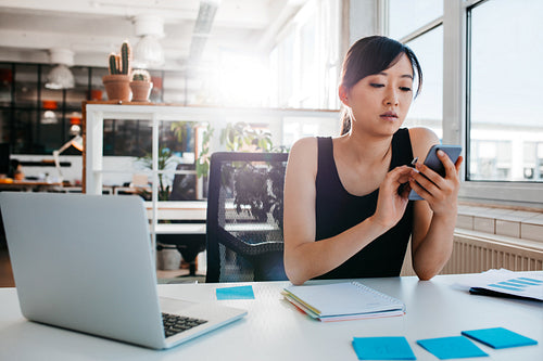 Young businesswoman using mobile phone at work