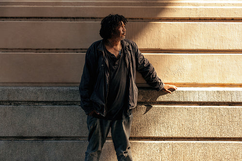Unemployed man looking away thoughtfully outdoors