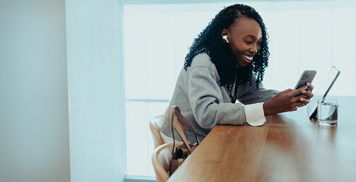 Smiling African businesswoman using smartphone