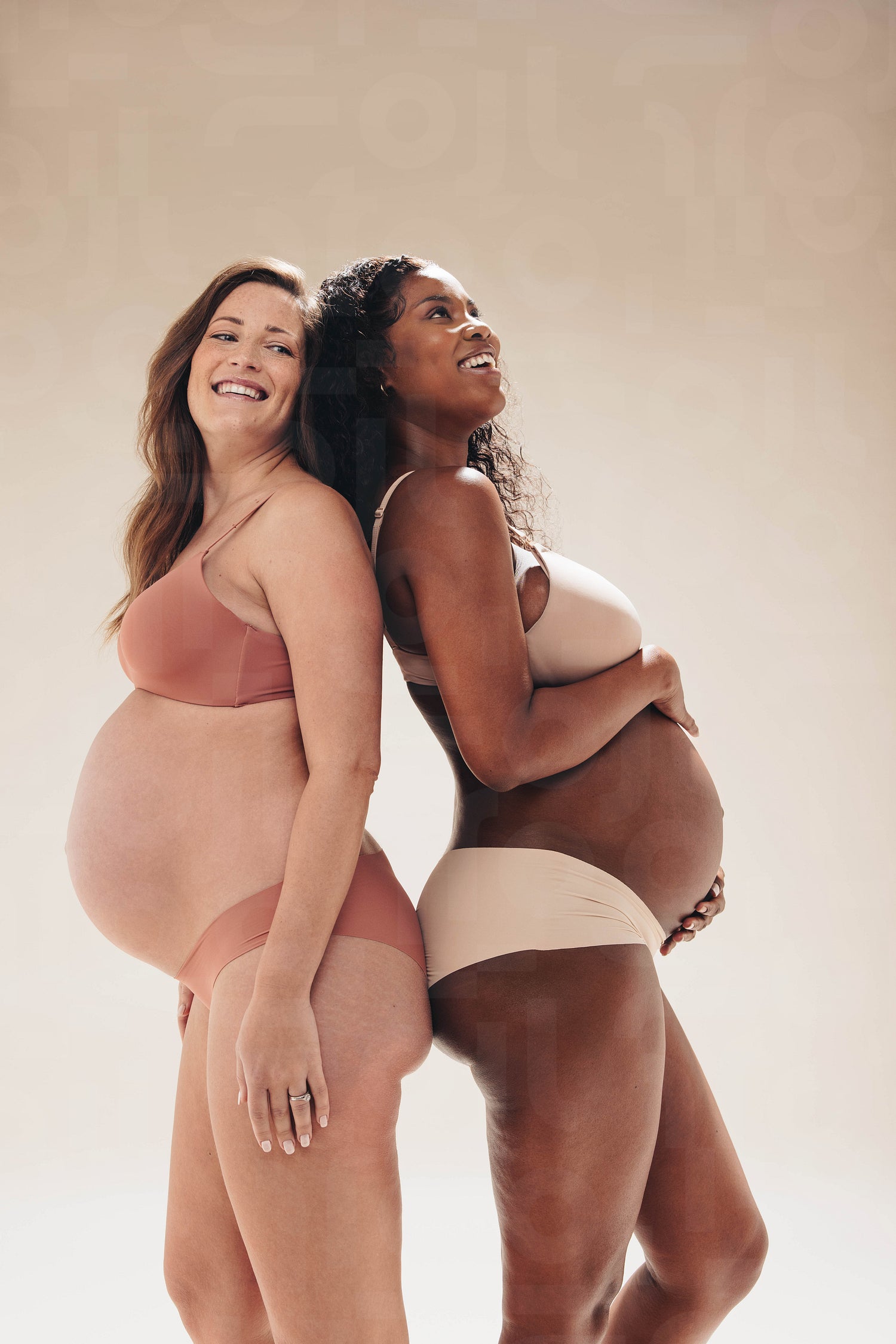 Pregnant friends wearing lingerie with confidence in an antenatal studio shoot Pregnant friends wearing lingerie with confidence in an antenatal studio shoot