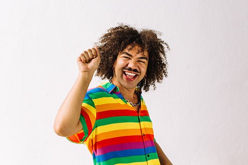 Happy young gay man celebrating in a studio