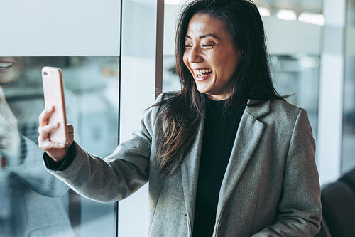 Woman having video call at airport waiting lounge