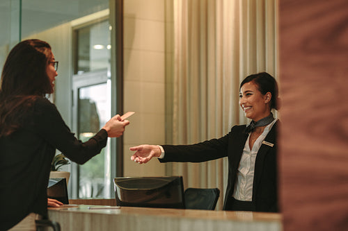 Woman settling her hotel bill with a credit card