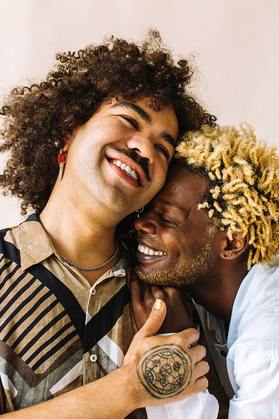 Cheerful gay couple embracing each other in a studio