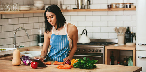 Beautiful woman watching recipe to prepare food in kitchen
