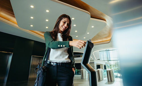 Smiling businesswoman swiping keycard at entrance checkpoint