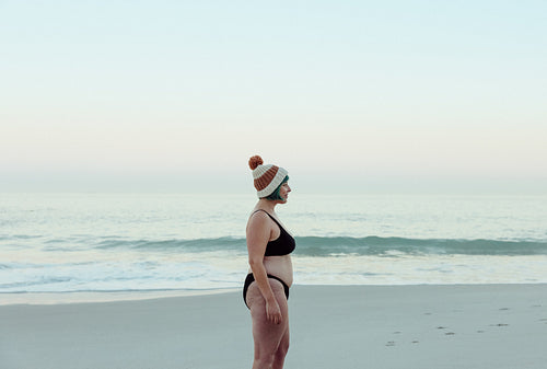 Sideview of a winter bather standing at the beach