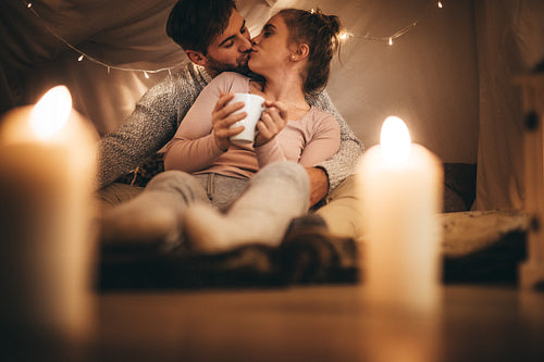 Romantic couple kissing each other sitting on bed