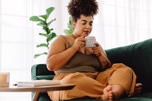 Pretty woman sitting on couch with coffee mug
