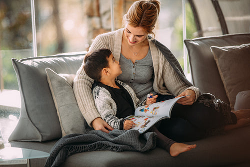 Mother and son with story book at home