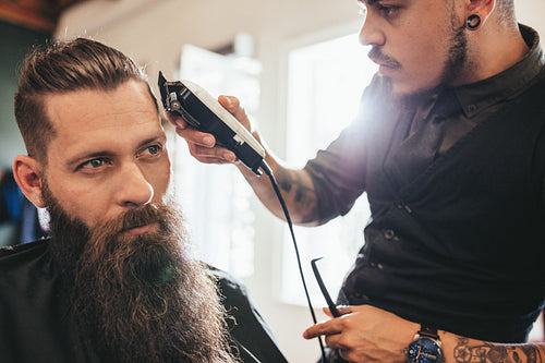 Young man getting haircut at barber shop
