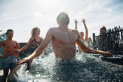 Community wellness moment unfolds as a man emerges from the ice bath with friends nearby
