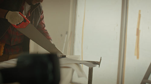 Bringing dreams to life: Man sawing wood during home renovation