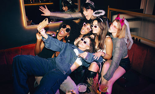 Group of friends posing together in a nightclub and enjoying themselves