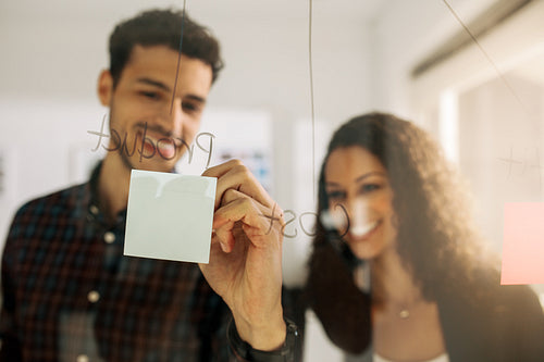 Business colleagues discussing business on a glass board in office