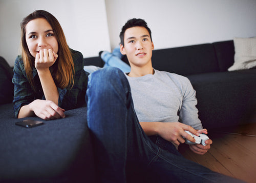 Teenage couple enjoying playing video game at home