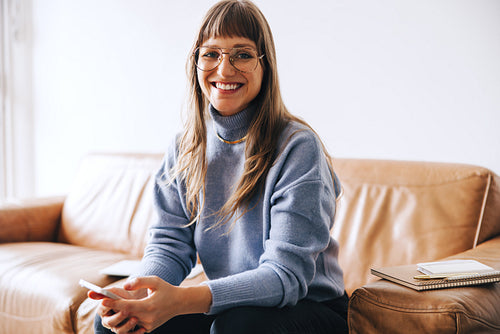 Cheerful young businesswoman smiling at the camera in an office lobby