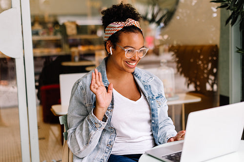 Happy entrepreneur working on laptop in cafe