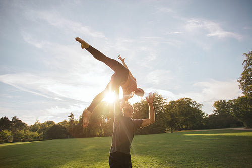 Fit couple doing acroyoga in park