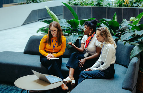 Trio of businesswomen collaborating in modern office environment