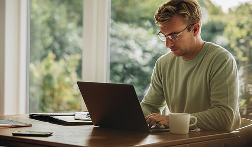 Young man working on laptop indoors