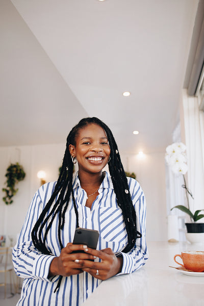 Cheerful young businesswoman smiling at the camera during her coffee break in a cafe