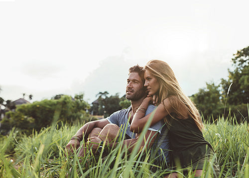 Young couple sitting together in meadow