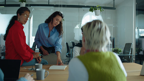 Coworkers collaborate in a business meeting around a conference table in a modern office