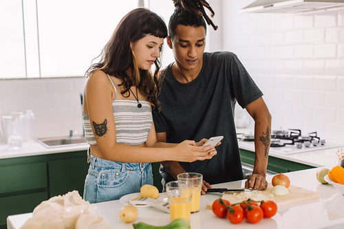 Young couple using an online recipe at home