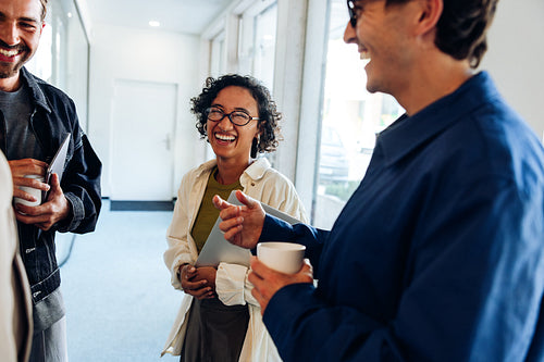 Office team of coworkers laughing during casual meeting