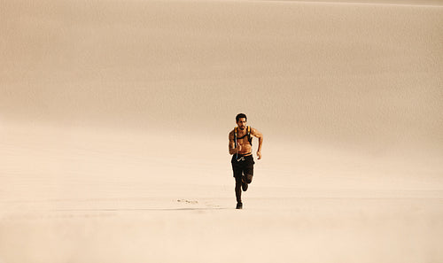 Fitness man running n desert
