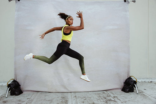 Female athlete in sportswear jumping midair