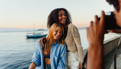 Smiling tourists posing at Mureta Da Urca during sunset