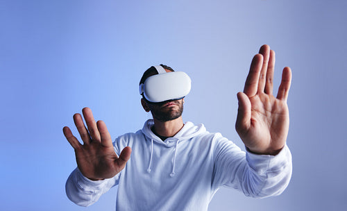 Curious young man touching virtual space with his hands