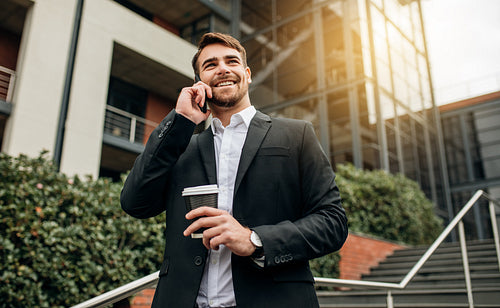 Businessman walking down the steps outdoors and talking on phone