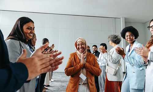 Diverse group of colleagues clapping and celebrating during a business meeting