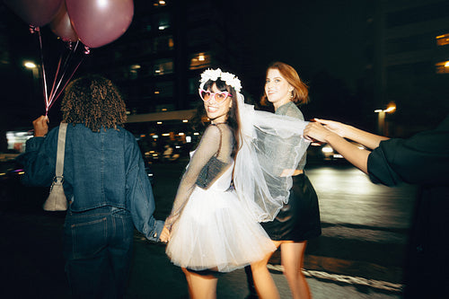Nighttime celebration with friends holding balloons and a festive atmosphere