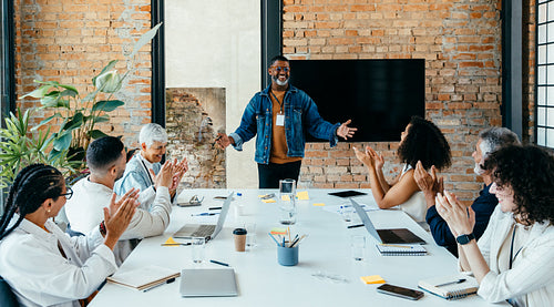 Confident CEO leads a successful meeting with diverse team in a sleek, open-plan office