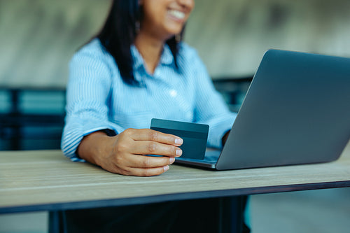 Woman shopping online at work with credit card