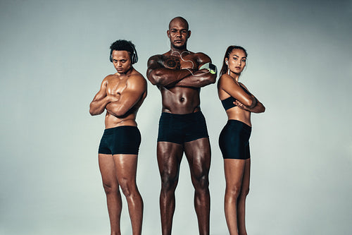 Group of young muscular people standing together