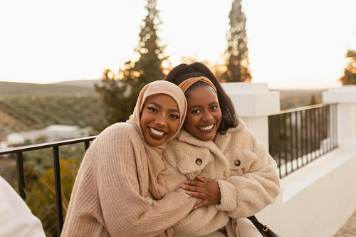 Two best friends smiling happily outdoors