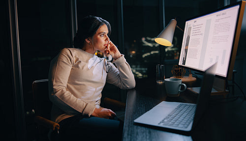 After hours project: Pensive businesswoman working late on laptop in home office