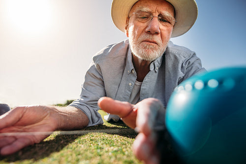 Senior man measuring the distance between boules