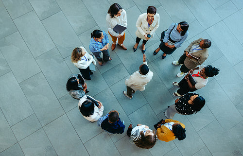 Top view of a corporate team huddle discussing onboarding and collaboration