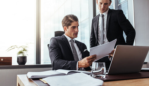 Corporate business people reading papers in office