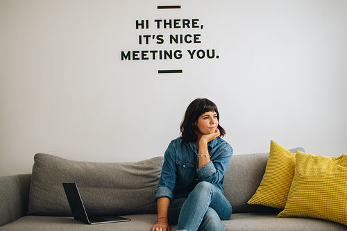 Thoughtful female entrepreneur on office sofa