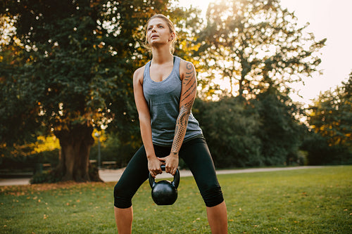 Strong young woman exercising with kettlebell