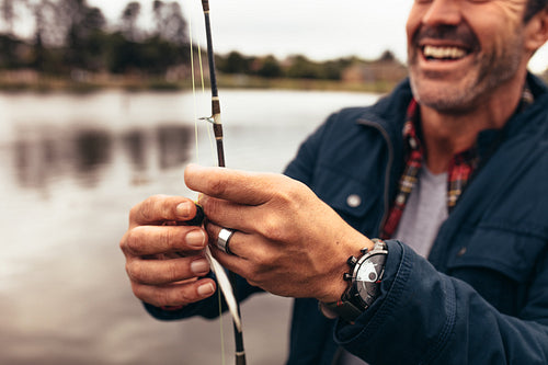 Close up of a man fishing near a lake
