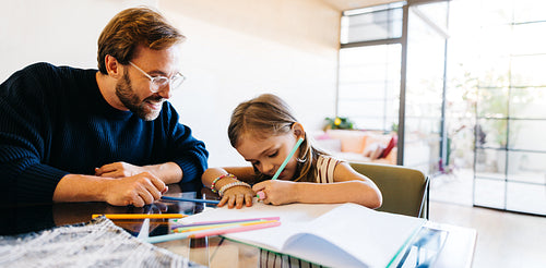 Father and daughter study at table