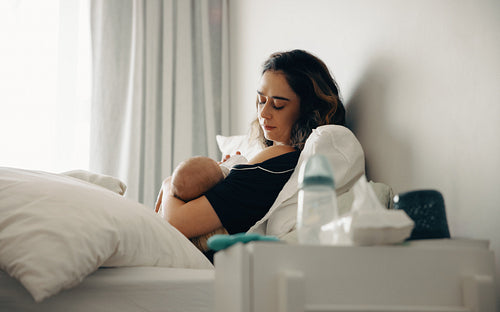 Mother feeding baby in bed